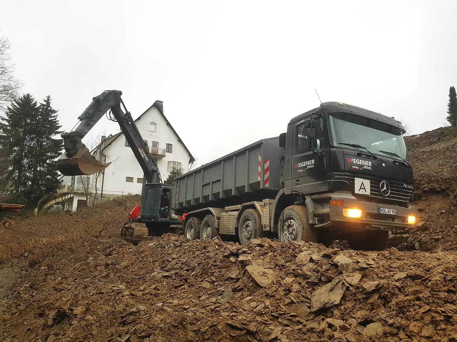 WEGENER Vierachser wird beim Erdaushub für die Seniorenresidenz in Winterberg vom Bagger beladen