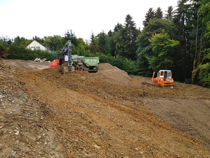 Großflächig abgeschobenes Grundstück mit Bagger und Planierraupe in Winterberg