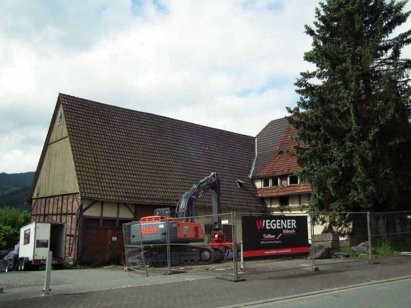 Das alte Fachwerkhaus Kropff in Olsberg vor dem Abbruch, davor WEGENER Bagger und Bauzaun