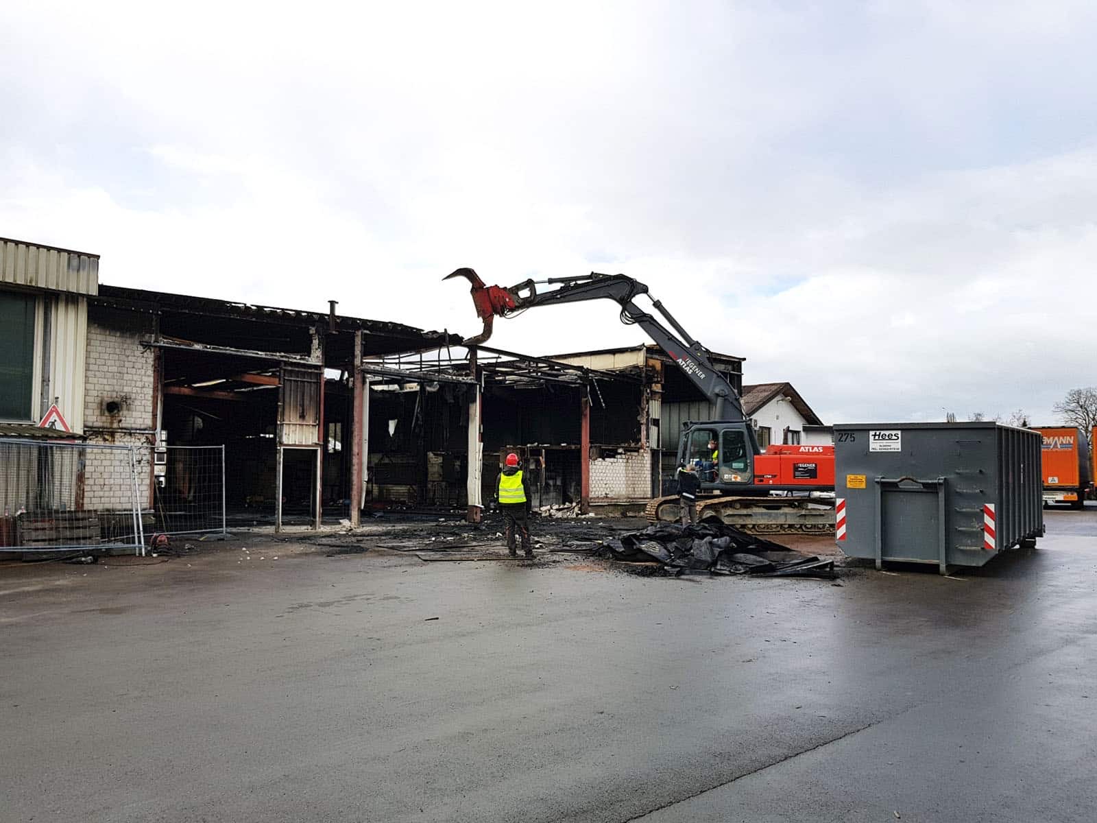 WEGENER Abbruchbagger mit Sortiergreifer trägt die brandgeschädigte Dachkonstruktion der Lagerhalle in Wrexen ab