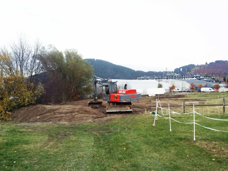 Mobilbagger planiert das freigelegte Wiesenstück für die neue Reitfläche in Willingen