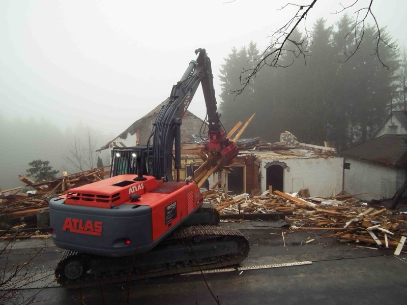 WEGENER Kettenbagger vor der abgebrochenen Haushälfte im Nebel